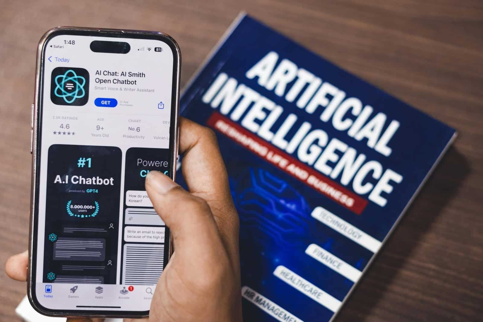 AI chatbot application displayed on a smartphone next to an artificial intelligence book