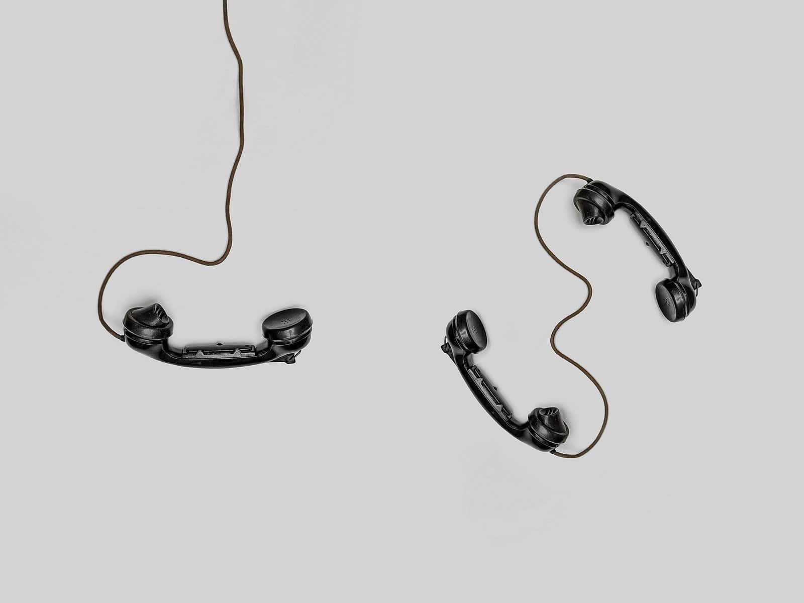 Vintage telephone handsets connected by wires representing AI voice agents and automated business communication