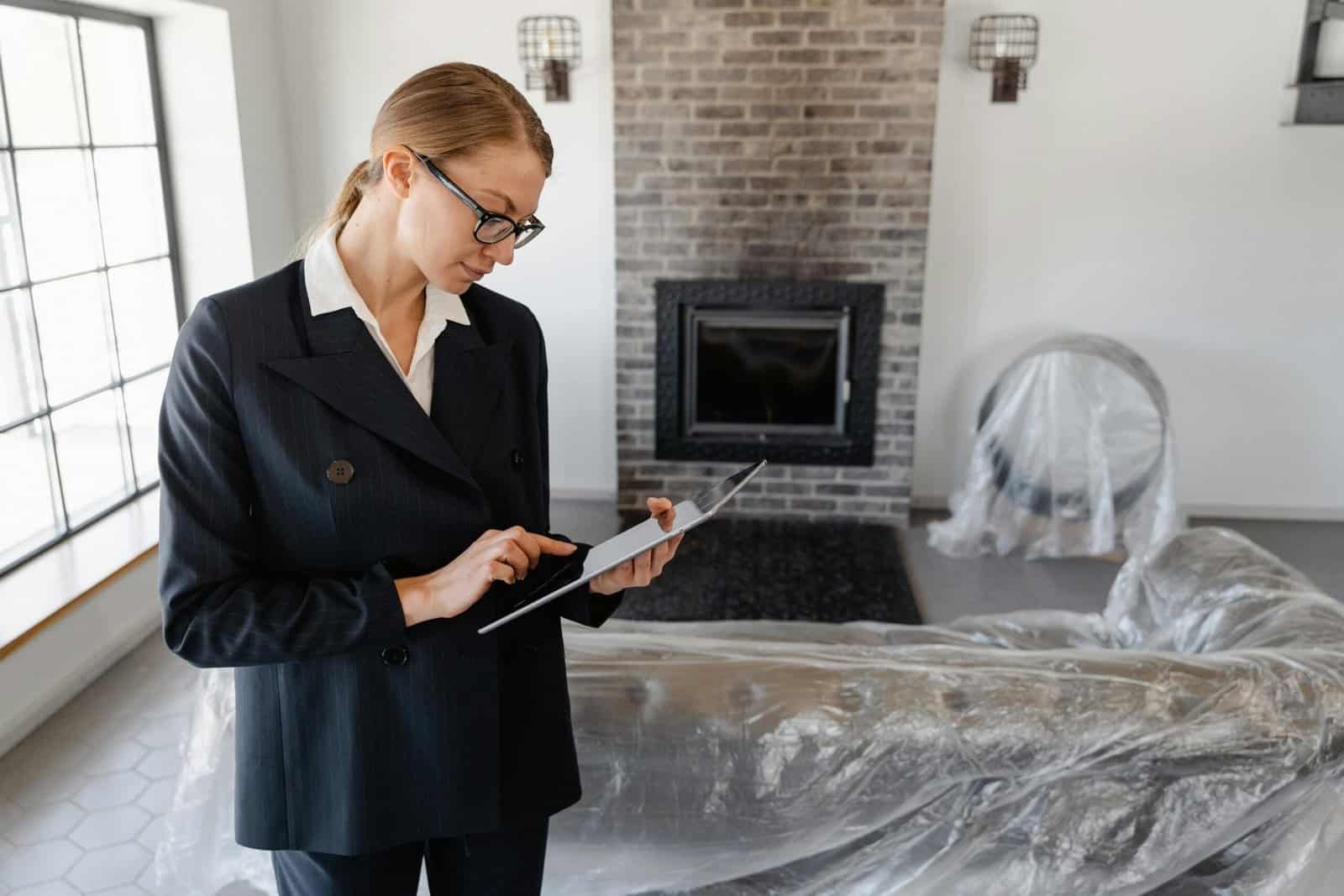 Real estate professional using a tablet inside a property during inspection, supporting real estate lead conversion and pipeline management.