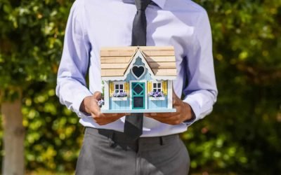Real estate professional holding a house model representing real estate lead automation and AI conversational chatbot solutions